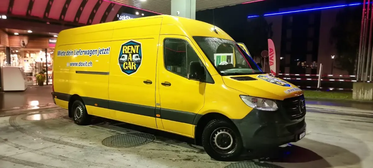 Yellow van for rent parked on a street