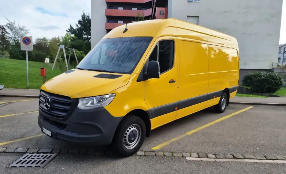 A yellow Mercedes Sprinter van parked on a street